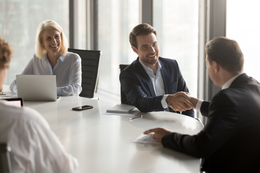 Business professionals shaking hands in a boardroom