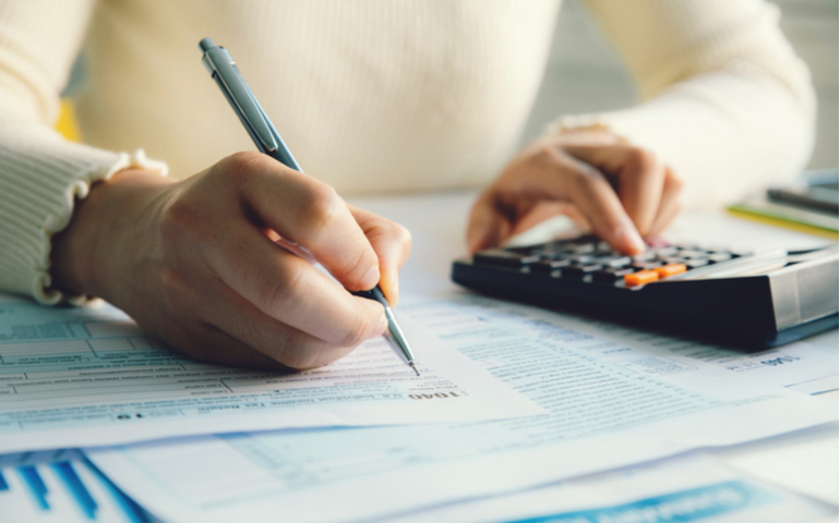 Person doing accounting with calculator