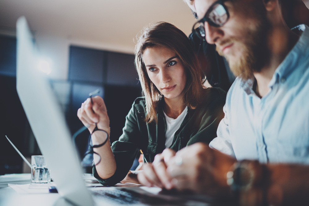 Man and woman looking at a computer in professional setting