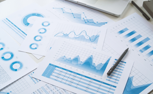 Collection of bar charts and graphs spread out on a desk