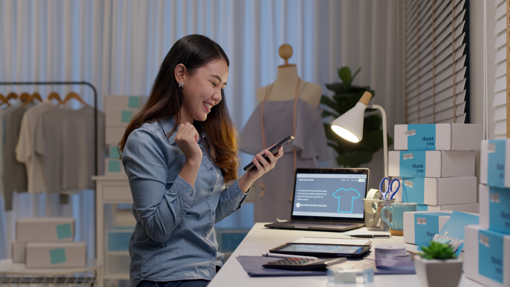 Happy business owner looking at phone