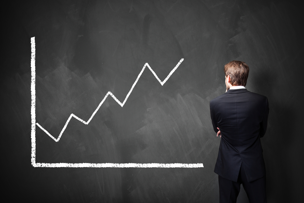 Businessman staring at an upwards graphc